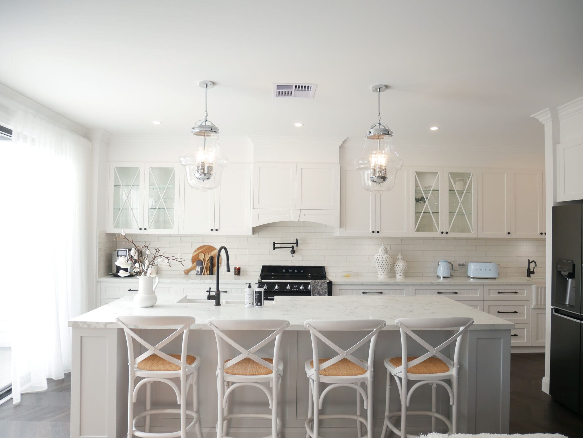 Elegant Modern Provincial Kitchen Design Modern provincial kitchen with white cabinetry, marble island, and glass pendant lights.