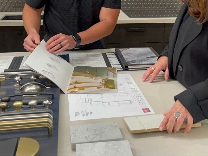 Kitchen designers presenting modern kitchen designs in a showroom with stylish finishes and contemporary layouts.