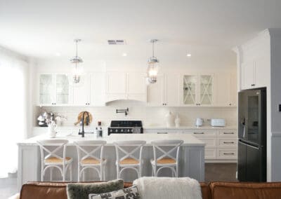 Modern provincial kitchen with white cabinetry, marble island, and glass pendant lights.