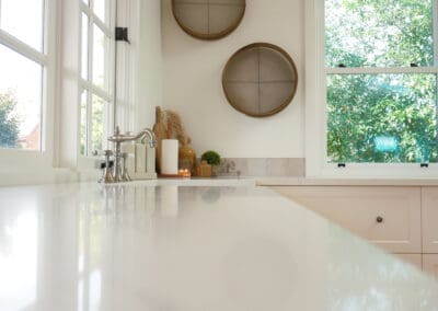 Deep ceramic Ovia farmhouse sink with traditional Fienza Lillian lever taps in a classic country kitchen.