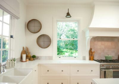 Soft-toned country kitchen featuring farmhouse sink and shaker cabinets