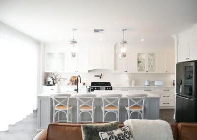 Modern provincial kitchen with white cabinetry, marble island, and glass pendant lights.