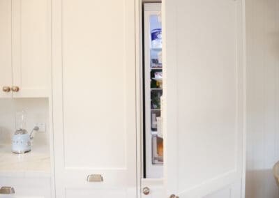 Shaker-style kitchen cabinets with an integrated fridge, seamlessly blending into the cabinetry for a clean, cohesive look.
