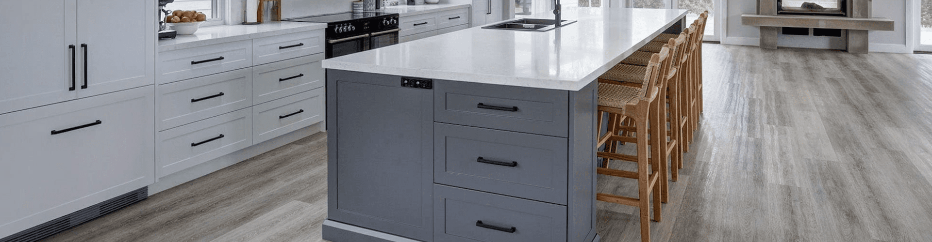 kitchen handles banner Spacious modern kitchen with black handles on white and navy cabinetry, featuring a large island with bar stools and a sleek cooktop.