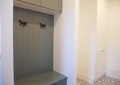 Mudroom with Porter's Hamptons Blue cabinetry and decorative horse hooks.