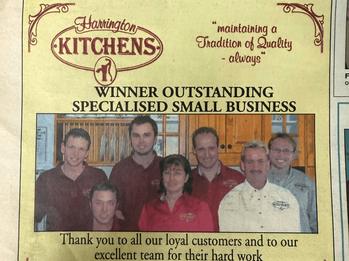 A newsletter clipping celebrating the Harrington Kitchens team after winning a local Small Business Award. The team is proudly pictured together, smiling and holding their award, with the article highlighting their craftsmanship, community commitment, and outstanding customer service.