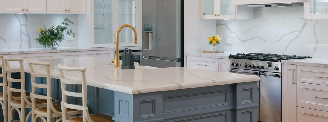 stylish kitchen benchtop with grey veining and gold tap