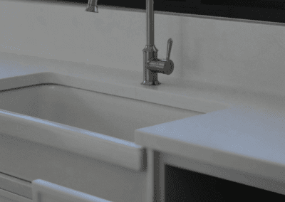 Picton Kitchen featuring a farmhouse sink, gooseneck tap and clever cabinetry hiding the kitchen bin system.