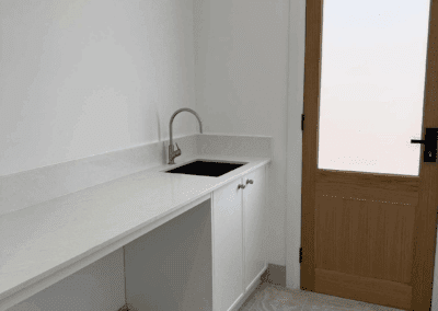 Laundry with white Colorado cabinetry, Phoenix Vivid tapware, and YDL Nuvola Snow stone benchtop.