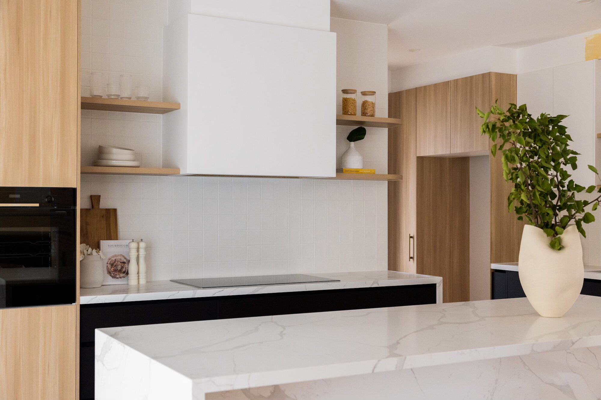 Minimalist kitchen rangehood custom made with flat box and timber shelves.