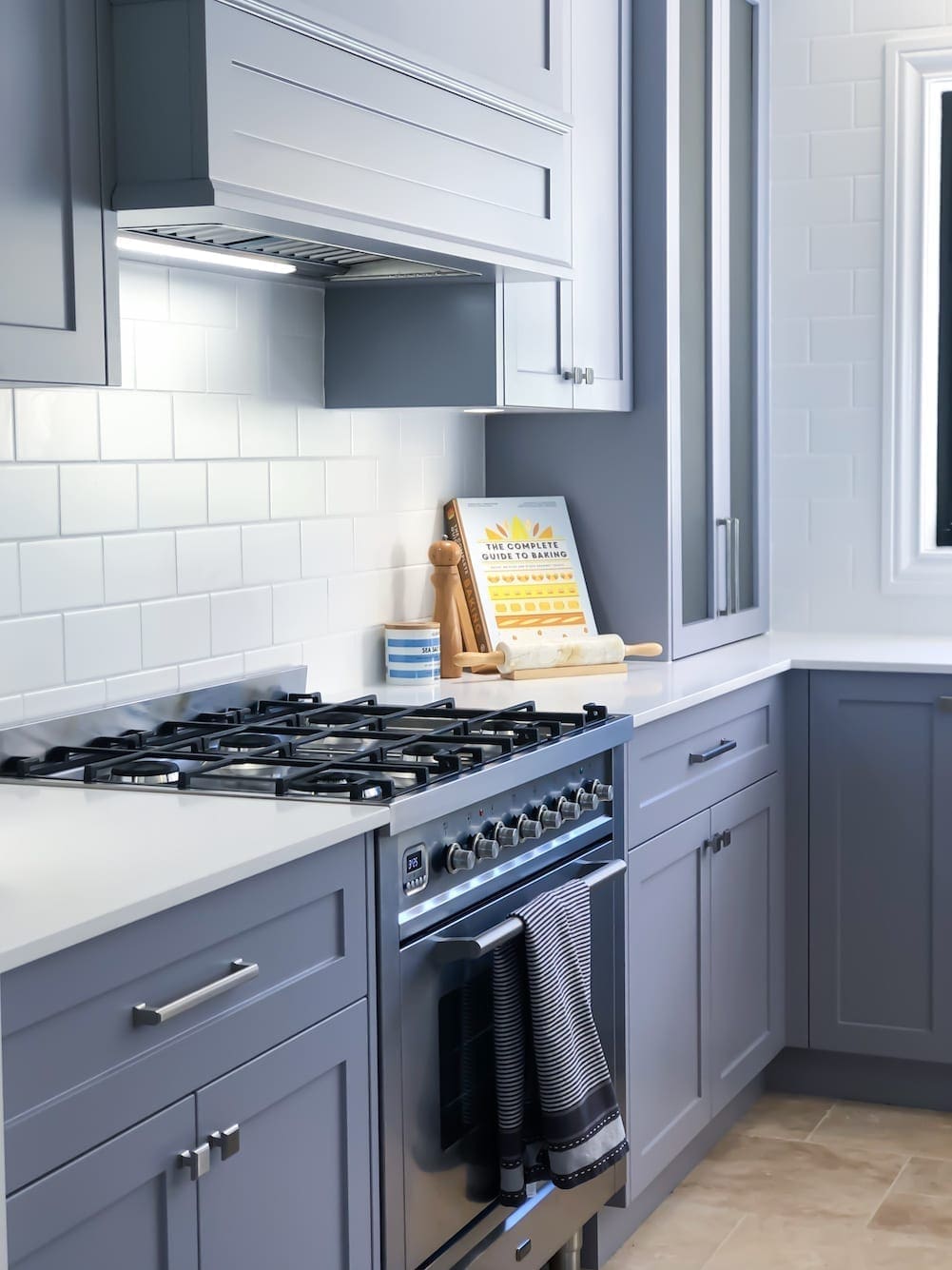 Shaker style kitchen with blue cabinetry, white subway tile splashback, gas cooktop, and stainless steel oven.