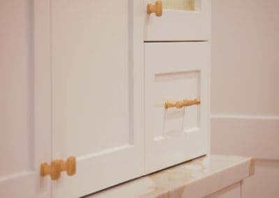 Champagne gold Esperance cabinet handles on white shaker cabinets in a classic kitchen.