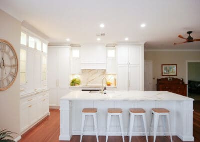 besoke kitchen with lambs tongue edging on the island, white shaker cabinets and gold handles