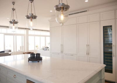 Built-in Sub-Zero wine fridge integrated within custom white shaker cabinetry.