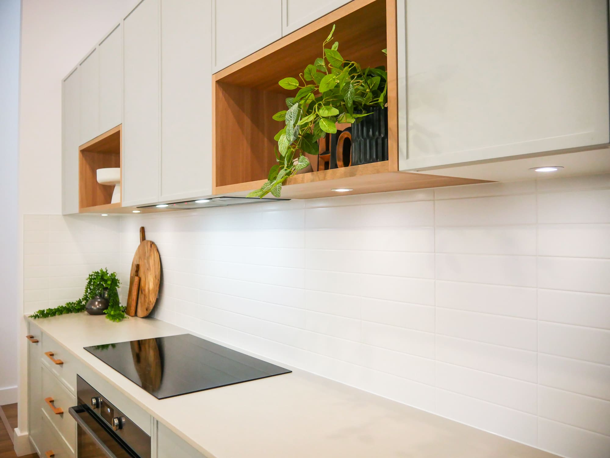 Modern kitchen with white subway kitchen splashback tiles and stylish green cabinets.