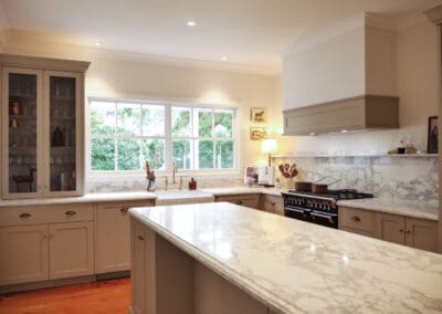 Timeless provincial kitchen with hand-painted cabinetry, marble island benchtop, and warm timber flooring
