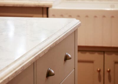 Close-up of marble kitchen benchtop with detailed edge profile and painted cabinetry