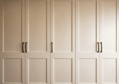 Custom warm white provincial pantry cabinetry with full height storage and brass handles.