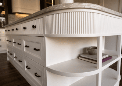 Custom fluted kitchen island with curved shelving, provincial drawers and stone benchtop.