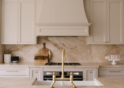 Luxury classic kitchen featuring a handcrafted rangehood, natural stone splashback, satin brass tapware and Chiefly cabinetry.